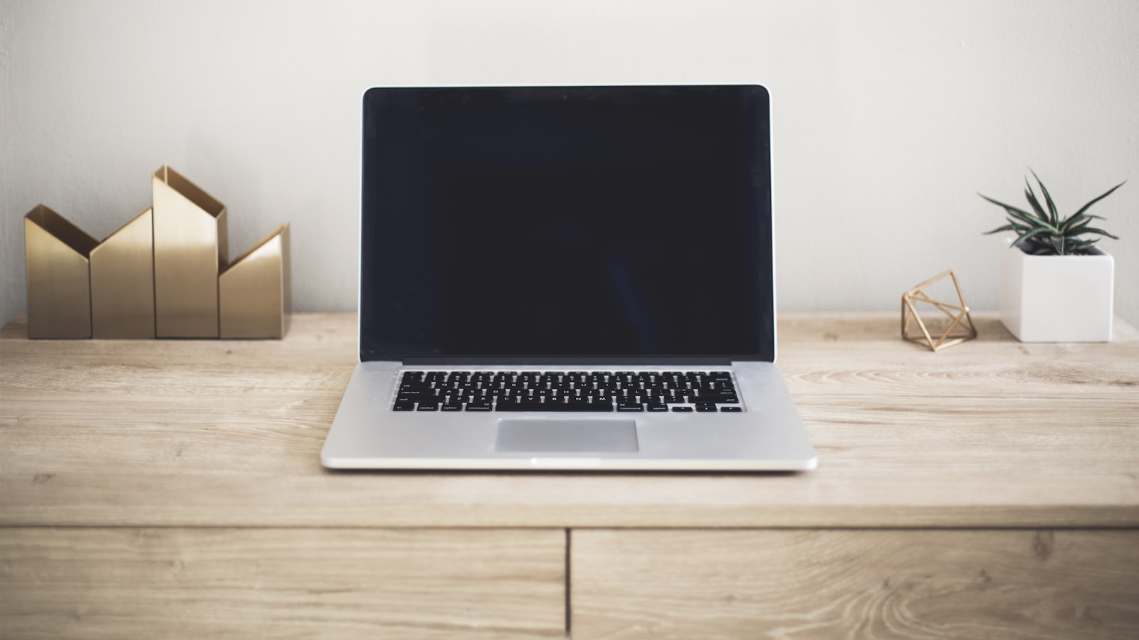 A laptop open on a desk beside an external hard drive, ready for a data transfer