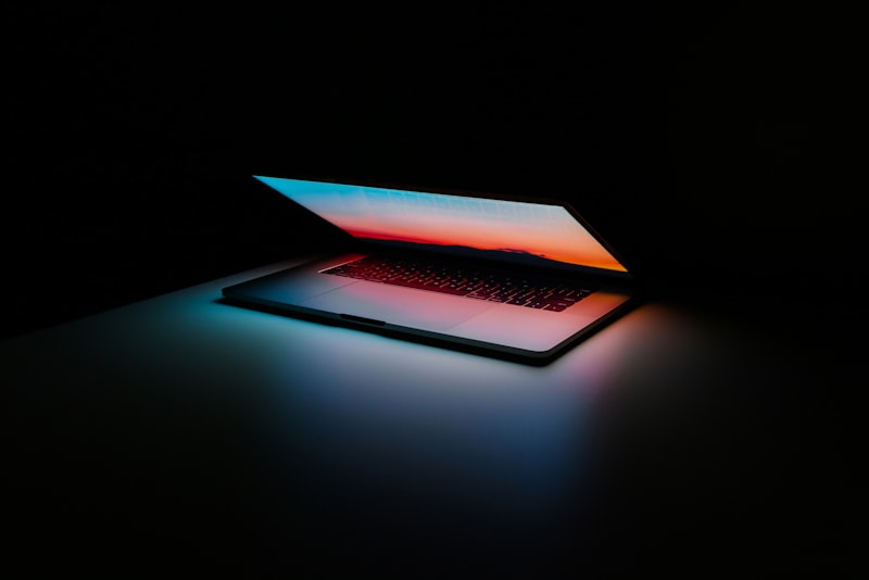 A person sitting calmly at a desk reviewing documents and a laptop screen